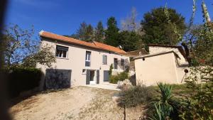a large white house on a hill with trees at Maison de campagne in La Fouillade