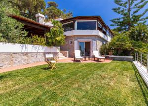 a house with a lawn in front of it at Villa Ritter Orizzonte in Cavoli