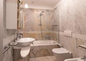 a bathroom with a sink and a toilet and a tub at Villa Ritter Orizzonte in Cavoli +19 photos
