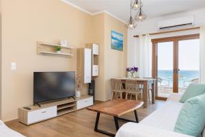 a living room with a television and a table at Azzure Studio in Kokkari