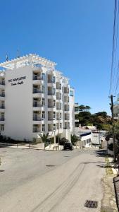 an empty street in front of a large apartment building at The Navigator - Ocean Heights & Residences in Olhos de Água