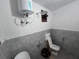 a bathroom with a white toilet and a sink at Batohi hotel cafe & Restaurant in Devaprayāg
