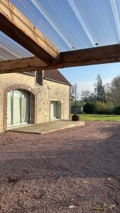a large brick building with a large window at Grange habitée, nature & design in Manou