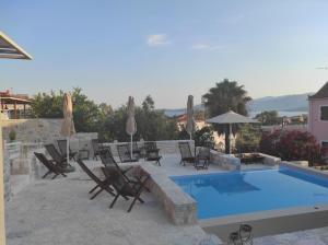 a patio with chairs and a swimming pool at Dimani Suites & Residences in Gythio