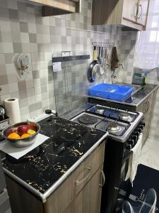 a kitchen with a stove and a bowl of fruit on the counter at Maple Lane Stays in Nakuru