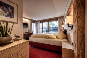 a hotel room with a bed and a window at AlpinArosa in Arosa