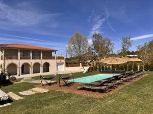 a swimming pool with lounge chairs and a house at Solar dos Arcos • Luxury Rural Retreat & Heated Po in Macieira da Lixa