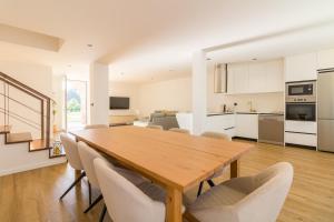 a kitchen and dining room with a wooden table and chairs at Solar dos Arcos • Luxury Rural Retreat & Heated Po in Macieira da Lixa