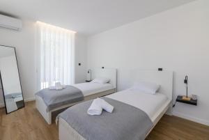a bedroom with two beds and a mirror at Solar dos Arcos • Luxury Rural Retreat & Heated Po in Macieira da Lixa
