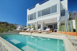 a house with a swimming pool in front of a house at Casa Roni by Xeno in Playa Estacahuite