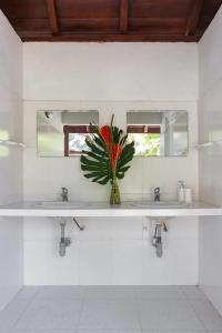 a bathroom with two sinks and a vase with a flower at Casa bela in Cartagena de Indias +6 photos