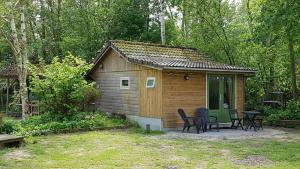 a small cabin with a table and chairs in a yard at The Hyacint House in Den Andel