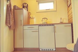 a kitchen with white cabinets and a refrigerator at The Hyacint House in Den Andel