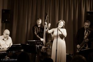 a woman in a dress singing into a microphone at The Hyacint House in Den Andel