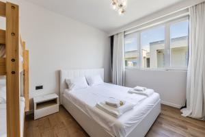 a white bedroom with a bed and a window at Talea Elegant Escape by PikHost in Lezhë