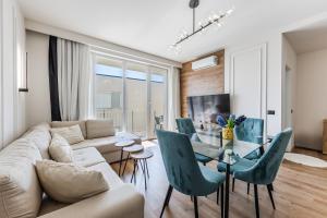 a living room with a couch and a table and chairs at Talea Elegant Escape by PikHost in Lezhë
