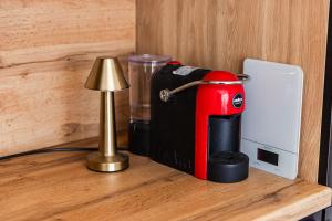 a red mixer sitting on a table next to a lamp at Talea Elegant Escape by PikHost in Lezhë