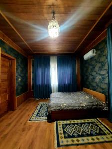 a bedroom with a bed and a chandelier at Brick House Melodies in Tsqaltubo