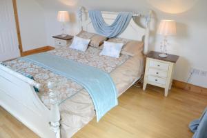 1 dormitorio con 1 cama blanca con dosel azul en Hook Head Guest House en Fethard on Sea
