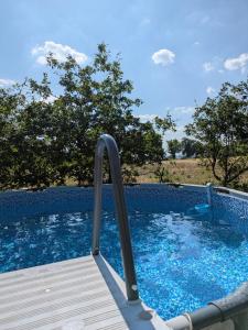 a plunge pool with a wooden deck and blue water at Bus magique avec tente glamping in Saint-Palais