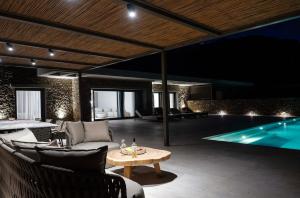 a living room with a table and a swimming pool at Fenia's Paradise Villa in Houlakia