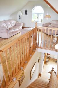 - un salon avec un escalier en bois et un canapé dans l'établissement Hook Head Guest House, à Fethard-on-Sea