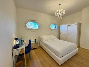 a bedroom with a bed and a desk and two windows at Santa Caterina 1604 Suites in Anzola dell'Emilia