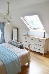 a bedroom with a bed and a dresser with a window at Hook Head Guest House in Fethard on Sea