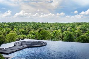 an infinity swimming pool with a view of a forest at Maison de Ecopark - Onsen & Spa in Kim Quan