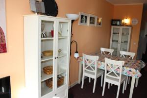a dining room with a table and white cabinets at Ferienwohnung an der Ostsee E311 in Brasilien +3 photos
