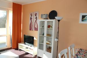 a living room with a white cabinet and a tv at Ferienwohnung an der Ostsee E311 in Brasilien
