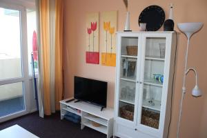 a living room with a tv and a white cabinet at Fereinwohnung an der Ostsee E312 in Schönberg