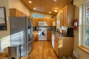 a kitchen with wooden cabinets and a stainless steel refrigerator at River Song Cabin home in Leavenworth
