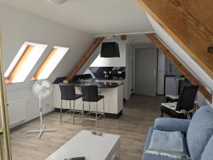 a living room with a couch and a kitchen with windows at Ferienwohnung in Schkölen in Schkölen +8 photos