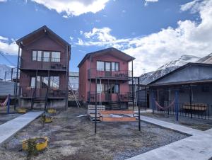 a playground with two houses and a swing at Nikolozi in Kazbegi