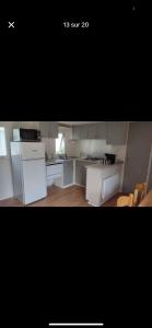 a kitchen with white appliances and a black background at Nature in Saint-Pierre-dʼOléron