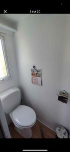 a white bathroom with a toilet and a window at Nature in Saint-Pierre-dʼOléron +9 photos