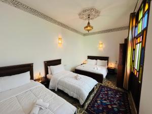 a bedroom with two beds and a window at Riad Fes Miracle in Fès al Bali
