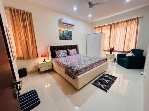 a bedroom with a bed and a couch and a chair at Premium Villa Stay Near the Airport Perfect for Families & Business Travelers in Hyderabad