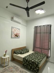 a bedroom with a bed and a ceiling fan at Rumah Homestay in Kangar