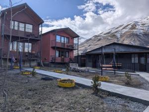 a group of buildings with a mountain in the background at cottage nikolozi in Kazbegi