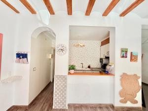 a kitchen with white walls and wooden ceilings at Villabett Caudiel está de moda in Caudiel