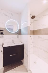 a bathroom with a sink and a shower at Hôtel de la Poste in Chablis