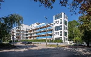 a tall white building in front of a street at FoBala Apartman in Balatonföldvár