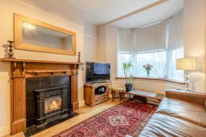 a living room with a couch and a fireplace at Character cottage with garden - Central Buxton in Buxton