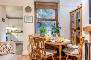 a kitchen and dining room with a wooden table and chairs at Character cottage with garden - Central Buxton in Buxton