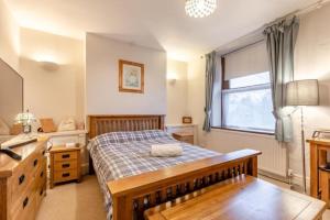 a bedroom with a bed and a desk and a sink at Character cottage with garden - Central Buxton in Buxton