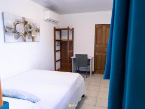 a bedroom with a bed and a table with plates on the wall at Le Clos de Ébéniers in Saint-Laurent du Maroni +27 photos