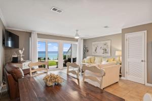 a living room with a couch and a table and chairs at Blue Tide #8A in Seacrest