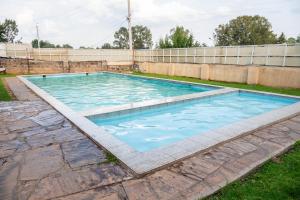 a swimming pool with blue water in a yard at Cozy urban homes in Nakuru